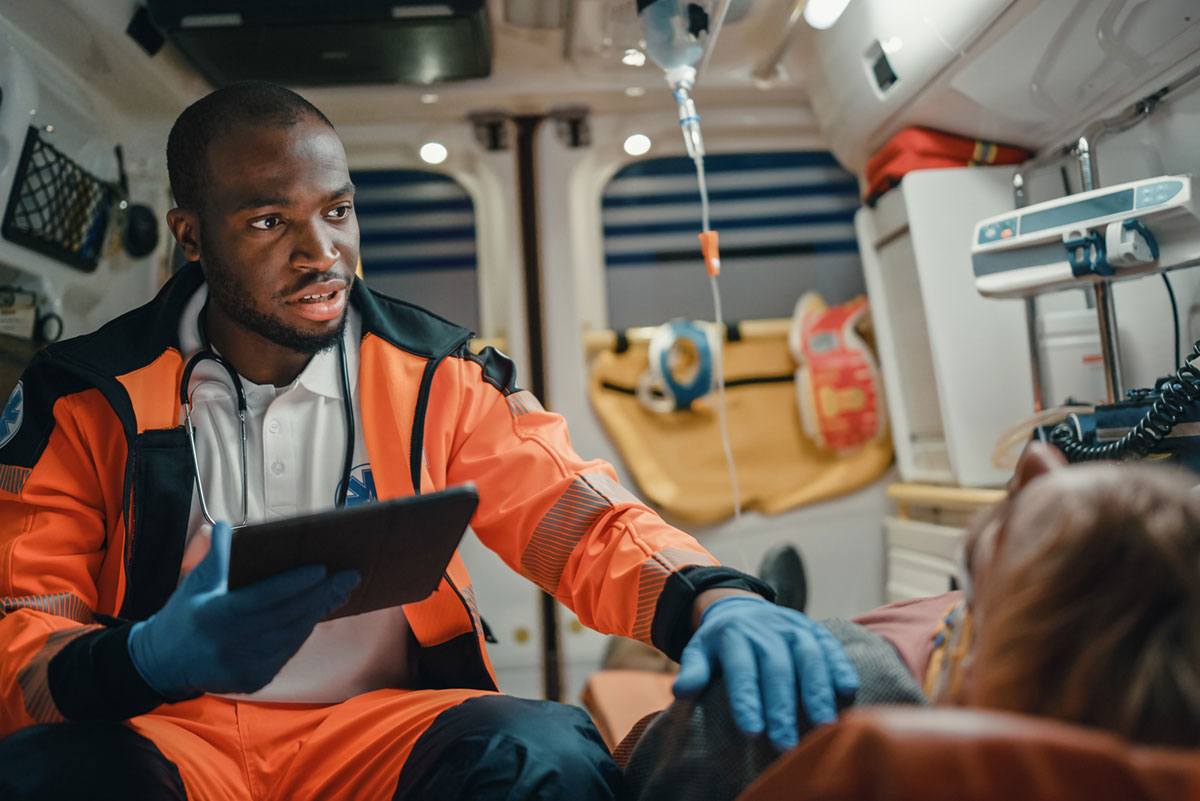 Man comforts patient in ambulance